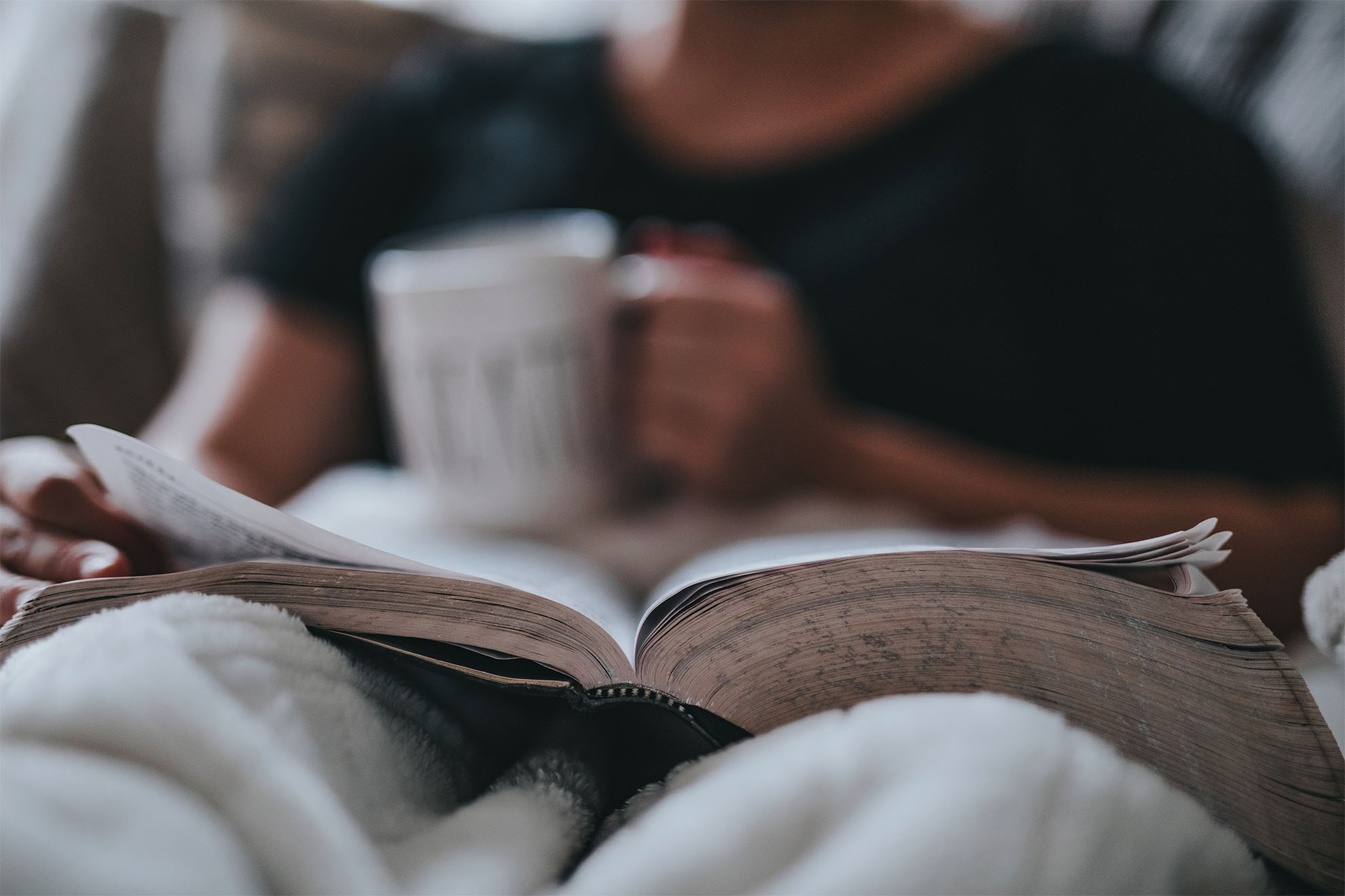 Resident reading a book with a cup of tea