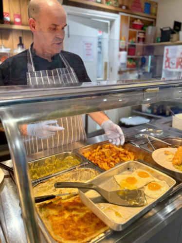 Chef serving food behing counter