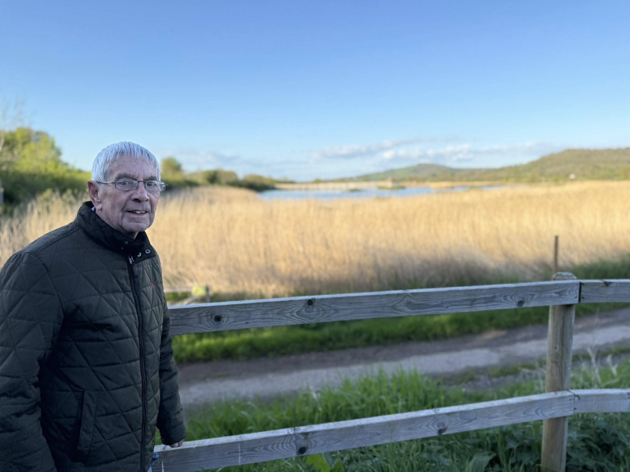 older man standing by a field