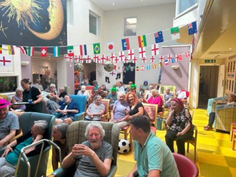 all residents are sitting together, smiling and enjoying the summer party